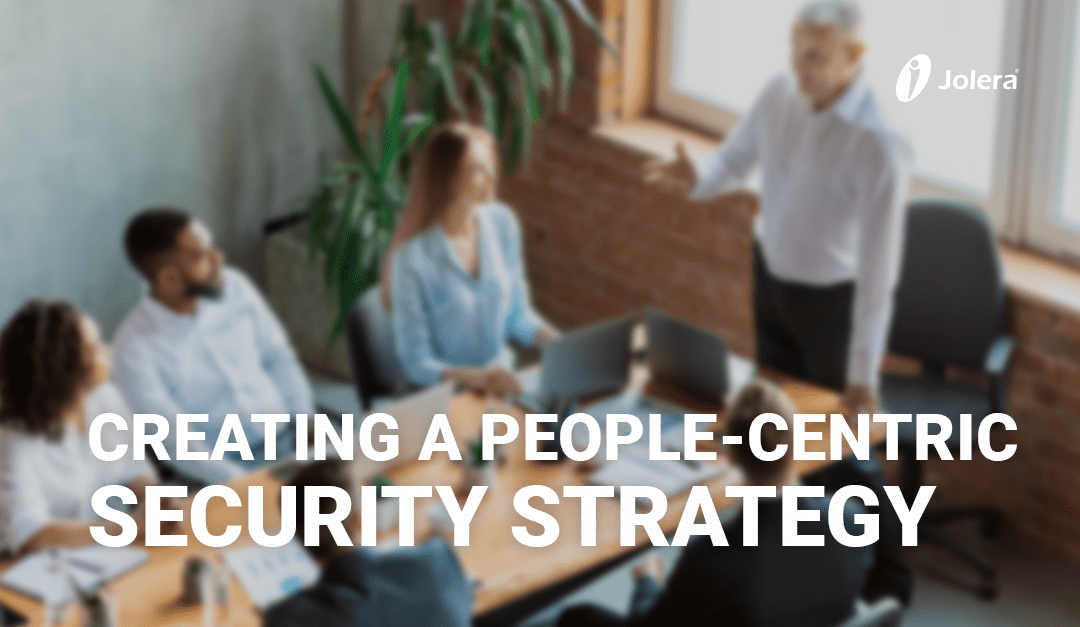 Employees sitting around a table, having a work meeting. Includes text overlay.